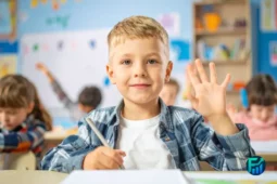 miling child raising hand in class, symbolizing education to children about financial literacy.