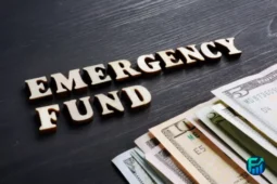 Wooden letters spelling “Emergency Fund” beside U.S. dollar bills.