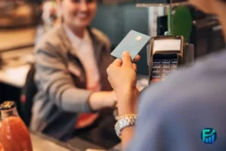 Person using a credit card at a payment terminal, symbolizing credit card rewards.