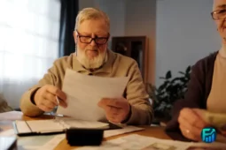 Senior man reviewing documents at home, representing housing options for seniors.