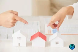 Hands pointing at small house models representing investing in U.S. real estate.