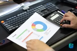 Person using a calculator and reviewing a budget chart for big purchase planning.