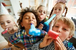 Group of children celebrating during kids’ parties with colorful hats and party blowers.