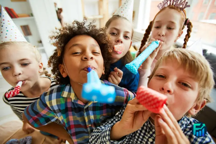 Group of children celebrating during kids’ parties with colorful hats and party blowers.