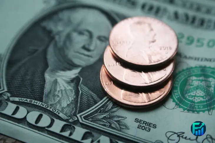 Close-up of U.S. dollar bills and coins representing the challenges of living on minimum wage.
