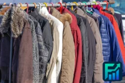 Various winter jackets hanging on a rack, symbolizing seasonal spending and the rise in winter costs for clothing and warmth.