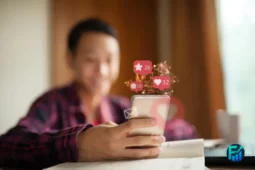 A person using a smartphone with floating social media icons, symbolizing online interaction and engagement.