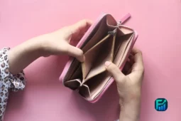 Hands holding an empty pink wallet, symbolizing the need to control spending.