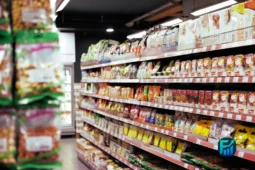 A supermarket aisle filled with colourful packaged snacks and pantry staples, captured during grocery shopping.
