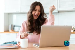Excited woman celebrating online success after removing the annual fee on credit card.
