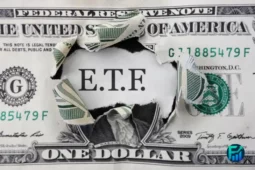 Torn dollar bill revealing the word ETF in the center.