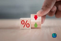 Wooden blocks with a percentage sign and arrows symbolizing lower interest rates.