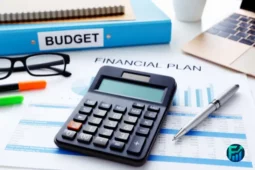 Calculator, documents, and laptop used for financial planning.
