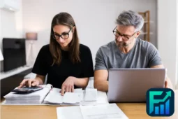 Couple calculating bills and reviewing documents with a laptop and calculator, illustrating how to budget money and manage personal finances efficiently.