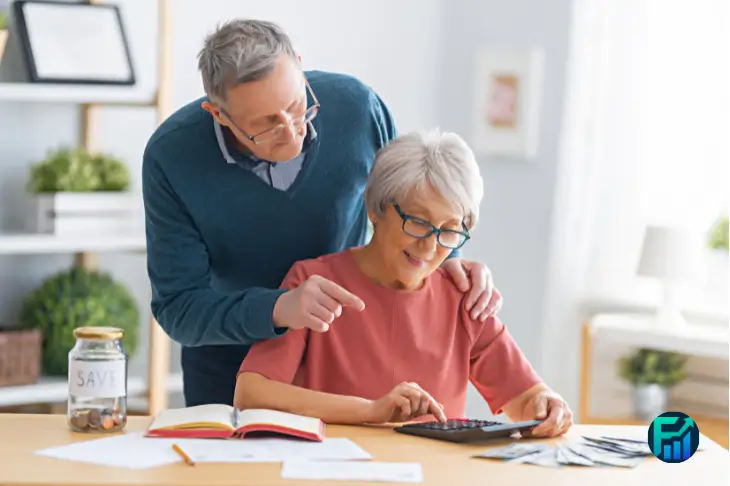 Elderly couple calculating bills and reviewing finances at home, representing how to manage the rising cost of living through smart budgeting.