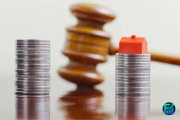 Stacks of coins divided by a judge’s gavel and a small house model, symbolising the division of assets during separation or divorce.