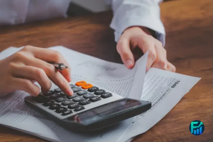 Hands reviewing tax documents and using a calculator during Tax Filing Prep.