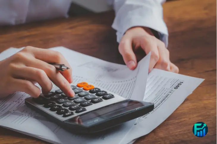 Hands reviewing tax documents and using a calculator during Tax Filing Prep.