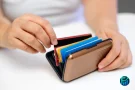 Person organizing cards inside a compact wallet, representing the best canadian credit cards for budgeting and credit building.