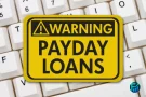 Warning sign about payday loans on a computer keyboard