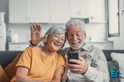 Senior couple using a smartphone at home, illustrating how the Lifeline Program helps eligible households stay connected with affordable phone service.