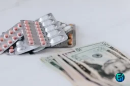Prescription medication packs and U.S. dollar bills illustrating ways to save money on prescription drugs through pharmacy discount apps.