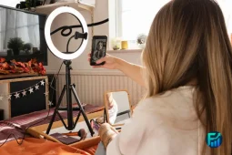 Content creator filming a TikTok Shop video with a smartphone and ring light.