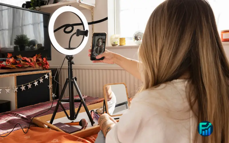 Content creator filming a TikTok Shop video with a smartphone and ring light.